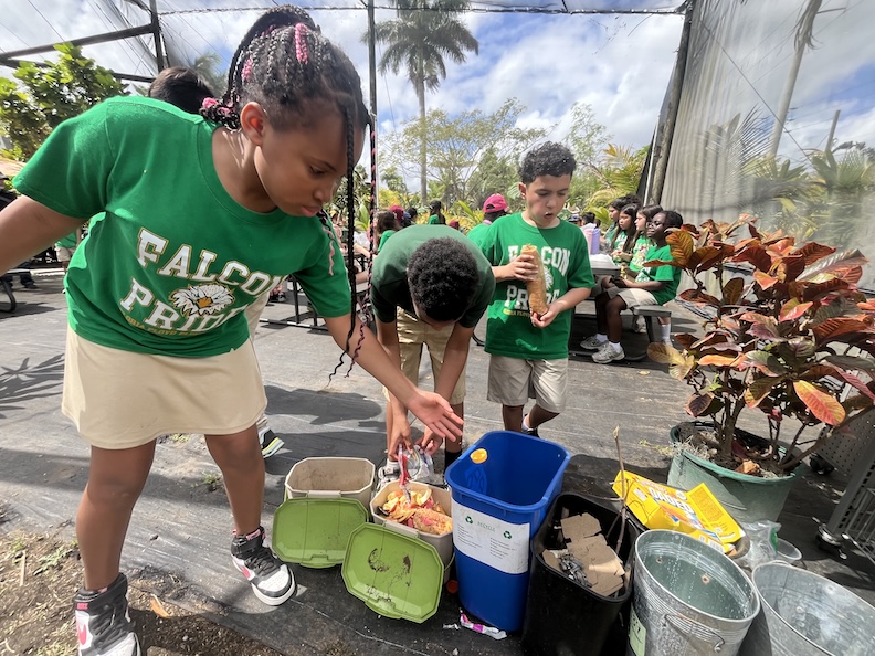 Students composting food scraps after lunch at Fertile Earth Worm Farm.