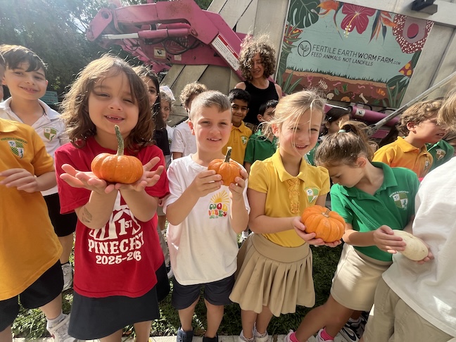 Pinecrest Elementary students holding small pumpkins