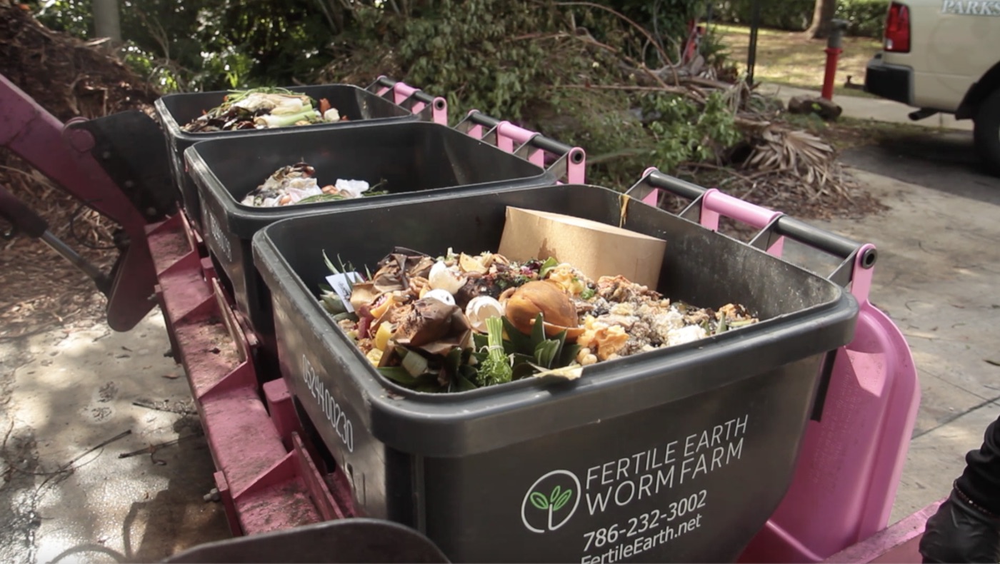 Fertile Earth food-scrap collection bins filled with organic materials on a pink lift