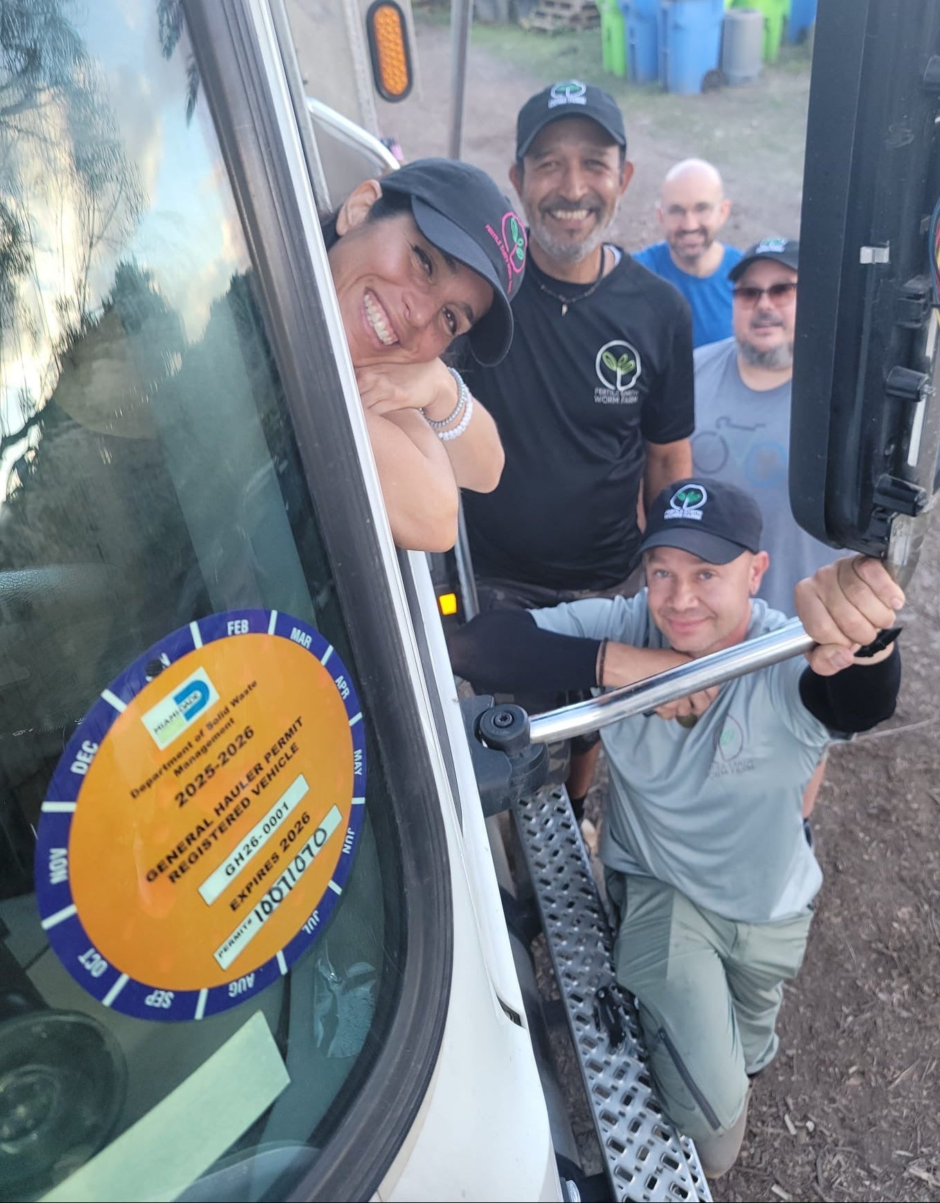 The compost team by the truck, showing hauler's permit